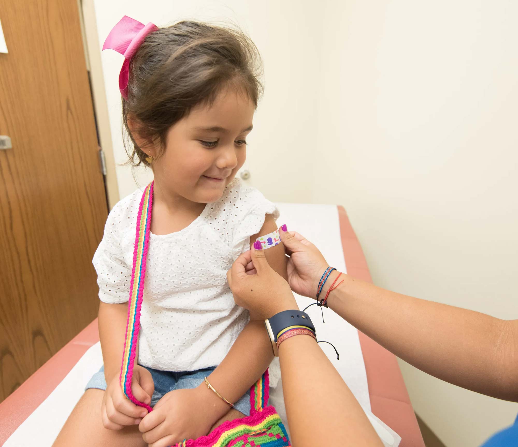 Child receiving bandaid after vaccination shot